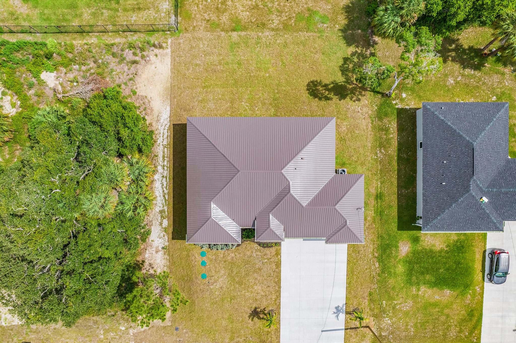 Top-down drone angle showing the dark shingle roofing and property layout of a new Ames Built home.