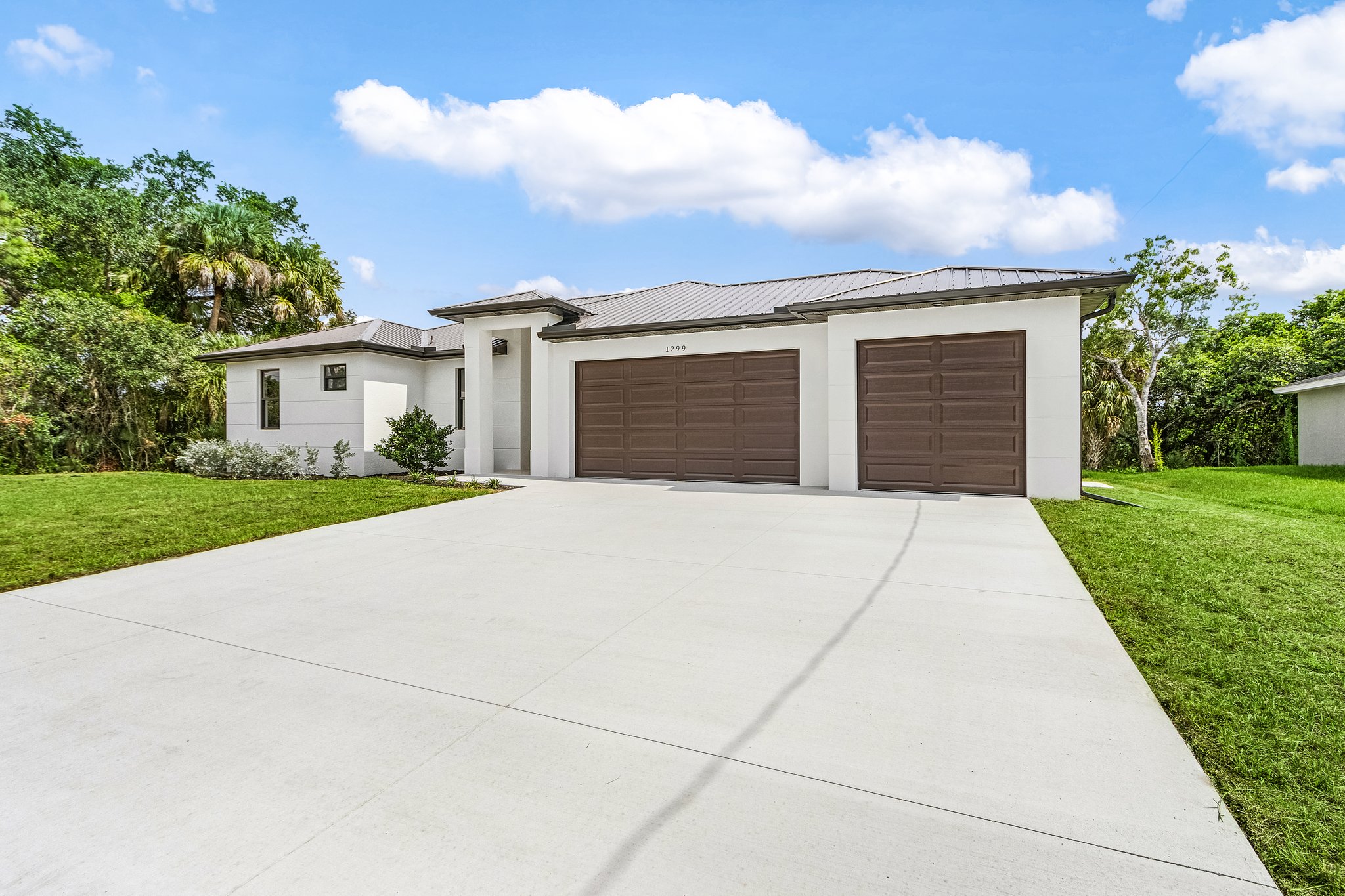 Spacious three-car garage and driveway on a modern Florida-style residence.