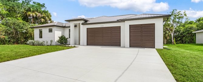 Spacious three-car garage and driveway on a modern Florida-style residence.